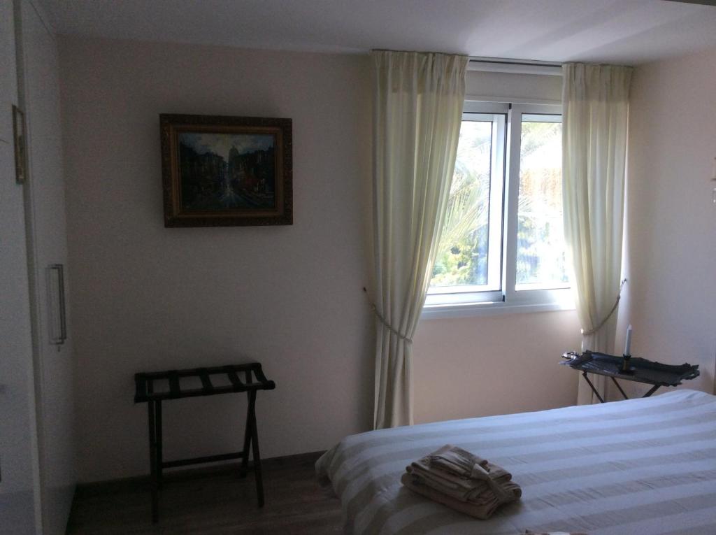 Second bedroom with cityscape painting and bright window at the Vintage Suite in central Nicosia