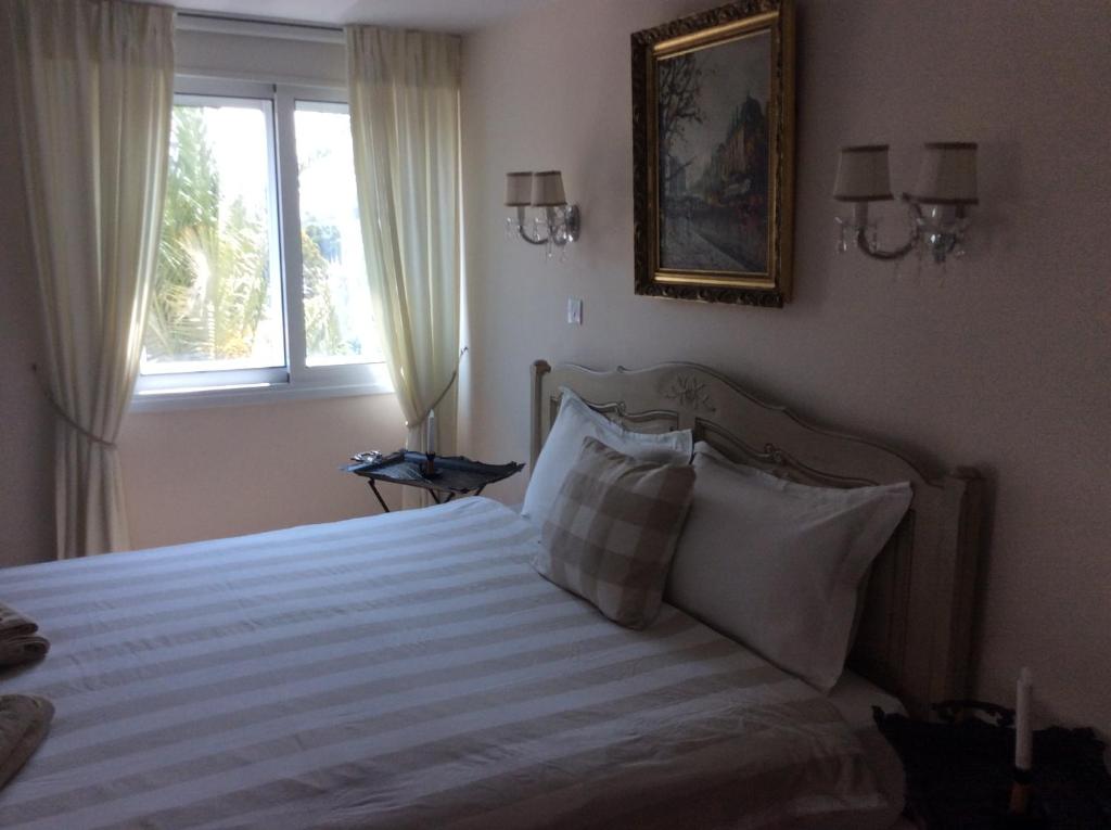 Double bed with wall sconces and framed city art in the Vintage Suite Nicosia bedroom