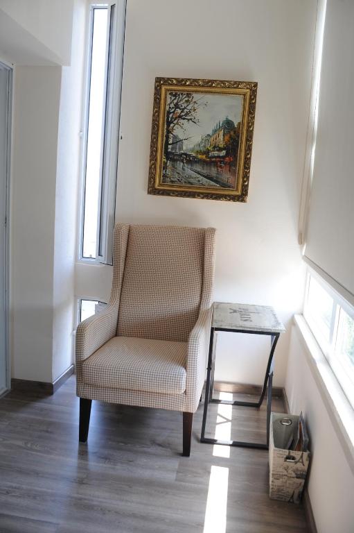 Bright reading nook with armchair and framed art at the Vintage Suite Nicosia