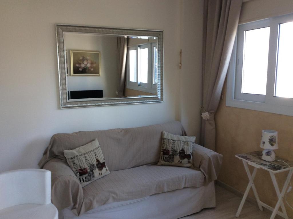 Fantasia Suite cosy sofa under a large mirror with cushions in central Nicosia apartment
