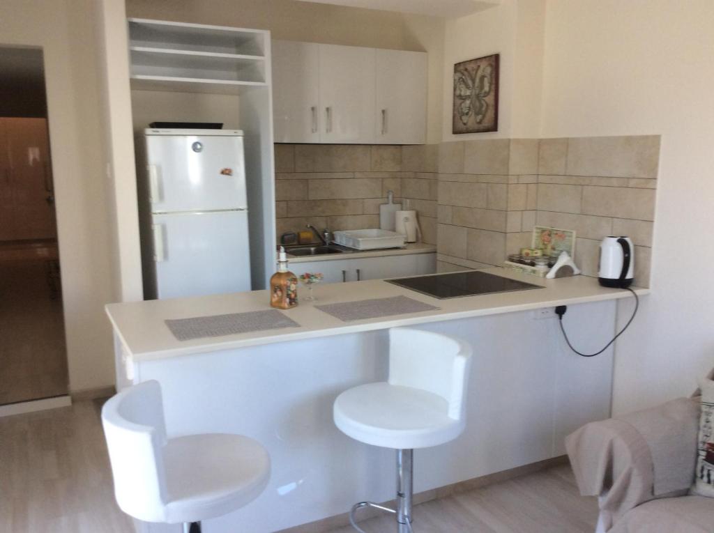 Fantasia Suite kitchen with breakfast bar, bar stools and full-size fridge in central Nicosia