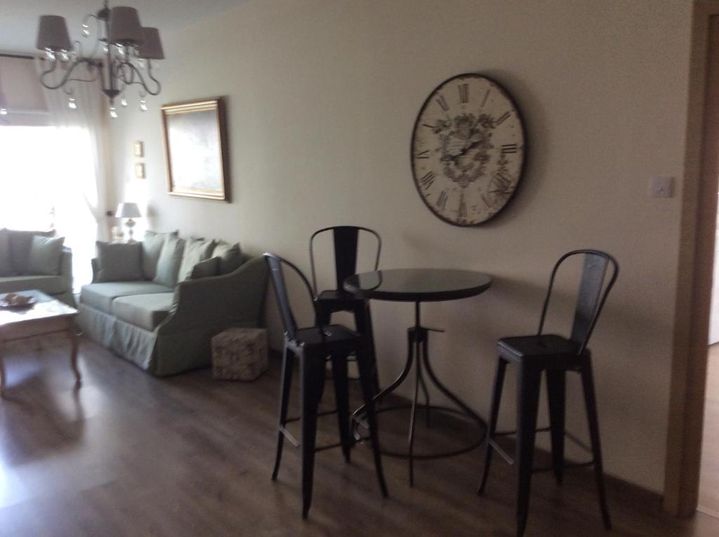 Sage green sofa and bistro table by the large clock in the Vintage Central Suite lounge, Nicosia
