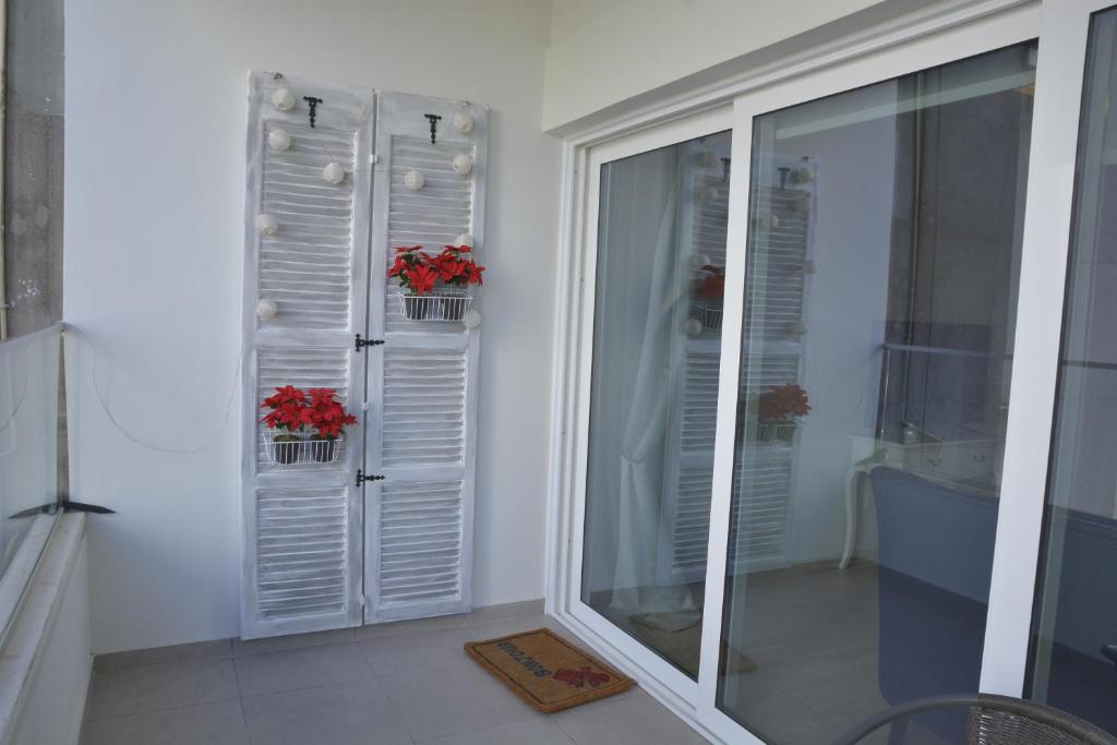 Balcony with white shutters and red poinsettias at the Armonia Central Suite Nicosia