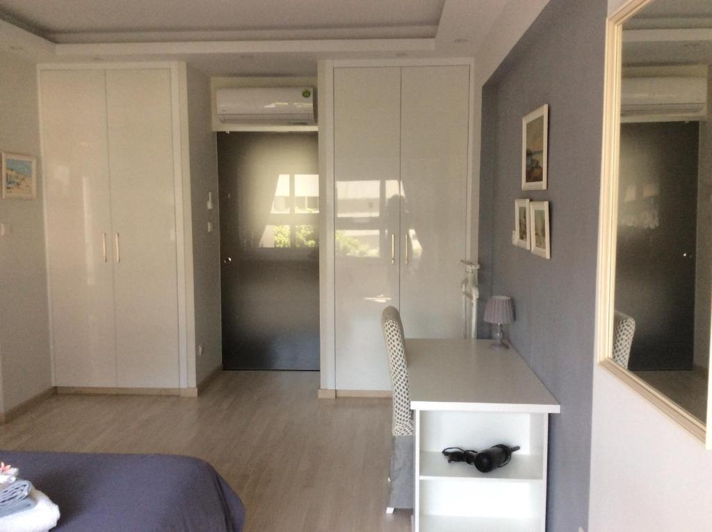 Fitted white wardrobes and dressing area in the Armonia Suite bedroom, central Nicosia