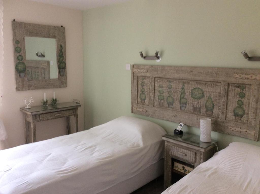 Twin beds with carved headboard and soft green walls in the Vintage Suite bedroom, central Nicosia