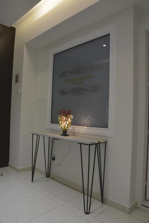 Entry console table with lamp under The Central Suites Nicosia signage at the Armonia Suite