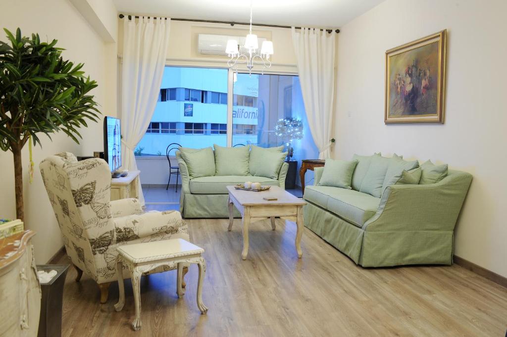 Vintage Suite open living room with sage green sofas and large window in central Nicosia