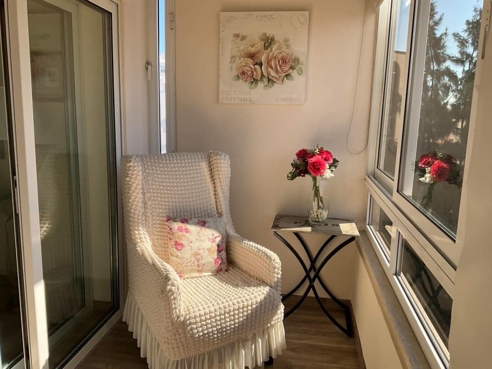 Enclosed balcony with armchair and flowers overlooking central Nicosia at the Vintage Suite