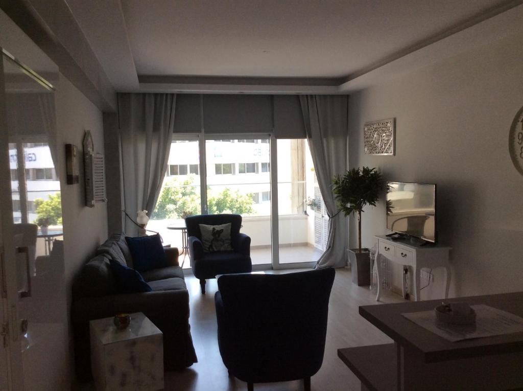Wide view of the Armonia Suite lounge with balcony doors and city light in central Nicosia