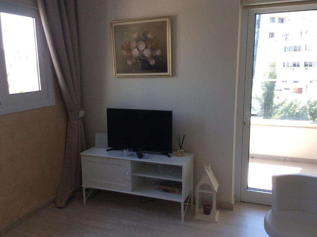 Fantasia Suite living area with flat-screen TV, framed art and balcony door in central Nicosia